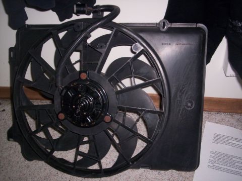 1989 Chevrolet Blazer - Radiator fan assembly part shown on carpet with some papers nearby.