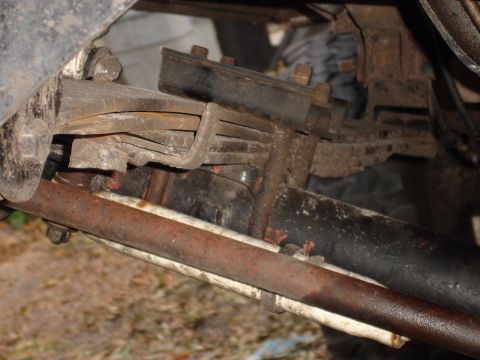 1989 Ford Bronco - Close-up view of a vehicle's rusty leaf spring suspension system.