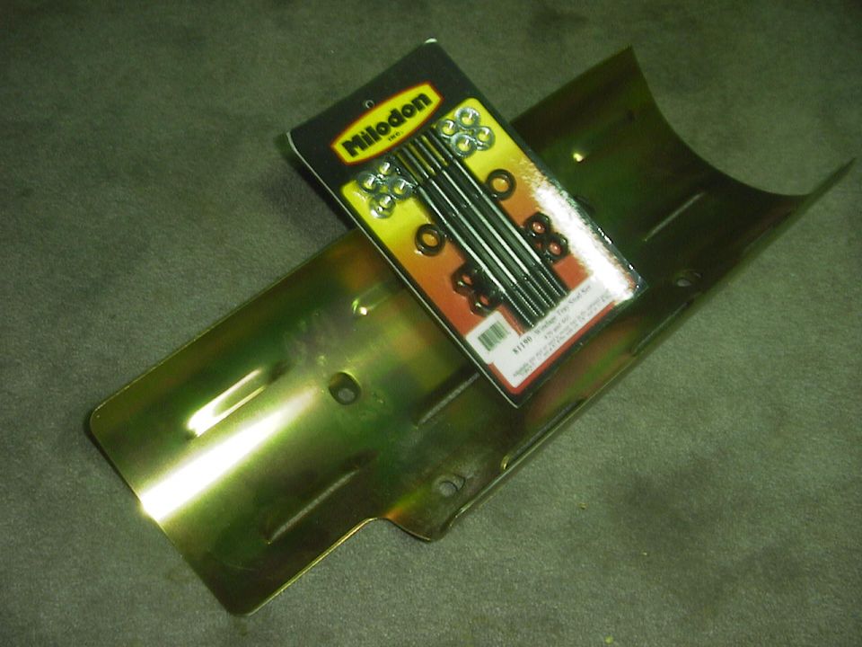 Yellowish metal engine part with a Milodon brand hardware kit on top