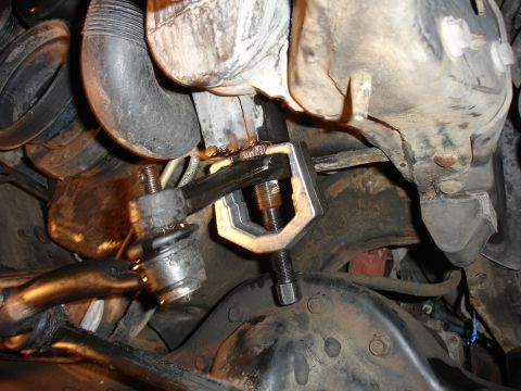 1996 Ford Bronco - A tie rod end removal tool is used on the suspension of a 1996 Ford Bronco during a lift installation.