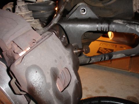 1996 Ford Bronco - Detail shot of vehicle suspension parts, possibly during a lift installation, with visible text from SuperMotors.net.