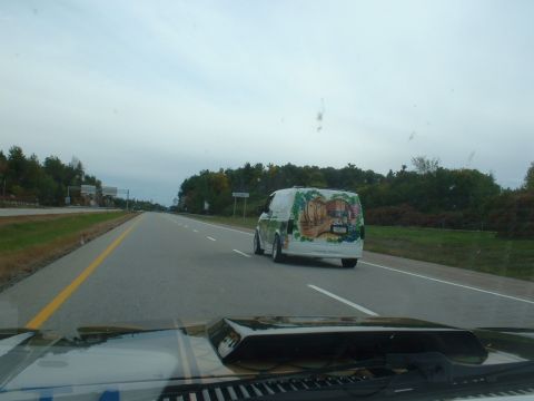 1978 Ford Mustang II - A van with a mural depicting a hobbit-like dwelling is seen driving on the highway.