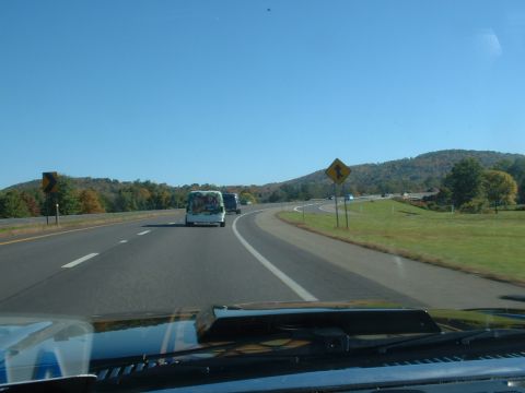 1978 Ford Mustang II - A van travels down a highway on a clear day with autumn foliage visible on the hills.