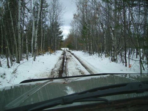 2000 Chevrolet Tahoe - Driving through a wooded area on a snowy, muddy track, with the vehicle's interior visible in the foreground.