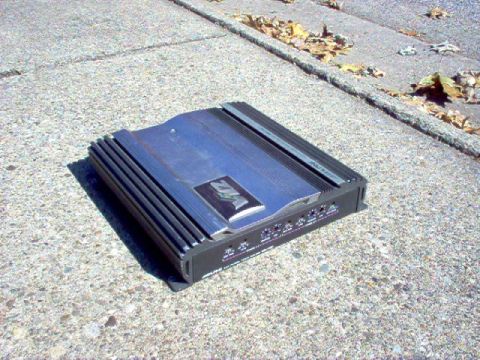 1994 Ford Probe - A car amplifier with a VFL logo is shown resting on a concrete surface with fallen leaves nearby.