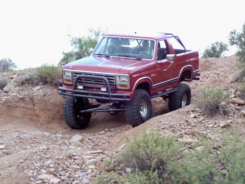 1991 Ford Bronco - Modified Ford Bronco navigates a rocky off-road path.