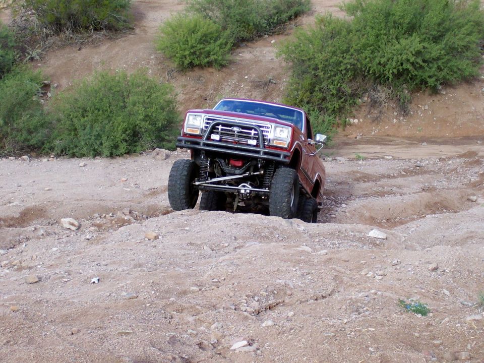 Red lifted off-road truck on a dirt trail