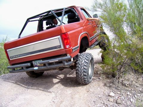 1991 Ford Bronco - This lifted Ford Bronco navigates a rough, off-road trail.