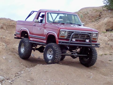 1991 Ford Bronco - This lifted Ford Bronco navigates a dirt trail, its off-road capabilities.