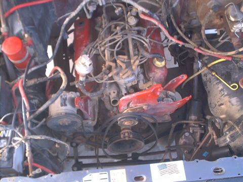 1986 Ford Bronco - Close-up view of a vehicle's engine bay, showing the distributor, spark plug wires, and various hoses.