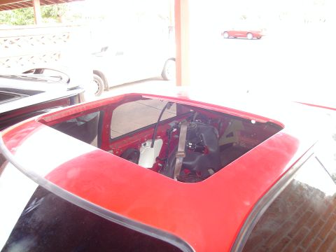 1997 Ford Probe - Interior view of a red car with the sunroof removed, revealing the frame and seatbelt mechanism.