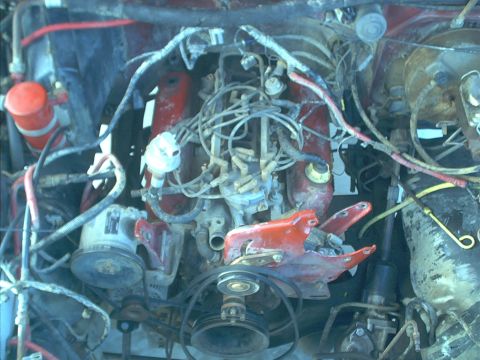 1986 Ford Bronco - The engine bay of a vehicle is shown with various components and wiring.