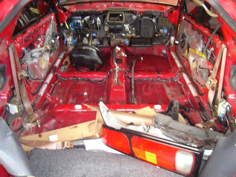 1997 Ford Probe - The interior of a red 1997 Ford Probe is completely disassembled, revealing its inner workings.