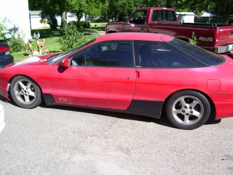 1993 Mazda MX-6 - This red coupe with black trim is seen from the side. It is a 1993 Ford Probe, not a Mazda MX-6 as initially suggested.