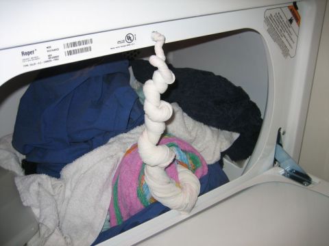 1986 Ford F-150 - A Roper dryer is filled with laundry, including blue, white, and dark colored items.