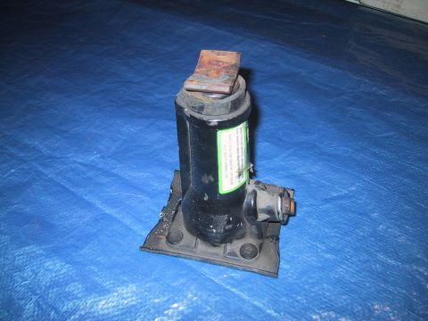 1994 Ford Bronco - A black car jack with a green label sits on a blue tarp.