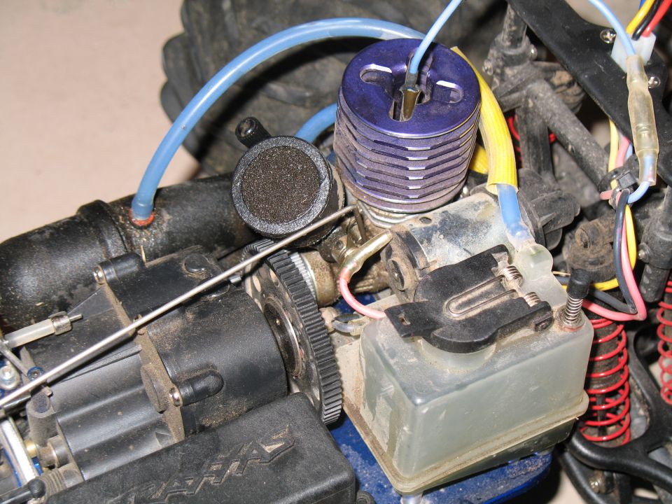 Close-up of a nitro RC car engine with blue heat sink head