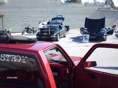 1995 Ford Probe - A black 1995 Ford Probe is displayed with its hood open at an outdoor car show.