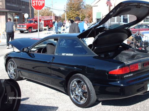 1995 Ford Probe - A black 1995 Ford Probe is displayed with its hood and trunk open at a car show.
