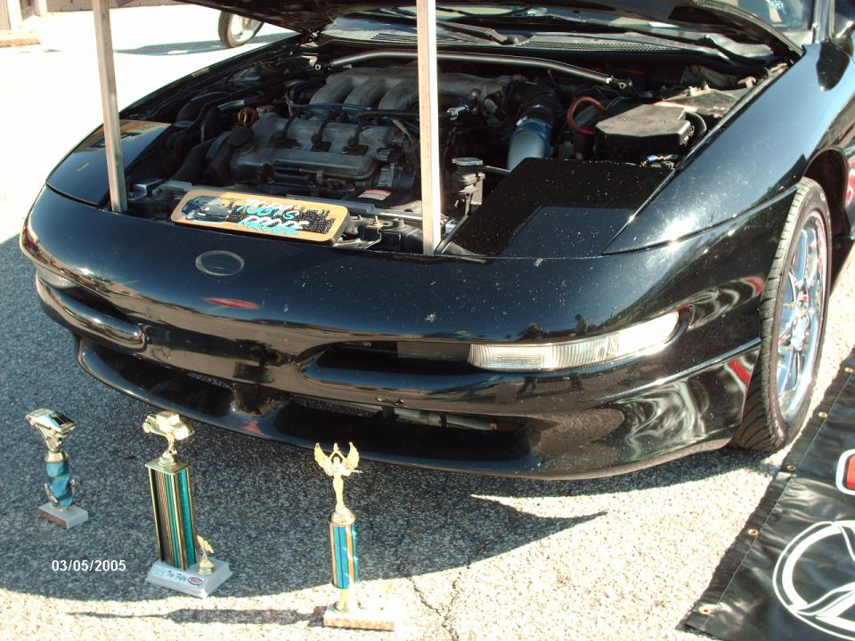 Black car with hood open, trophies in front, date 03/05/2005 visible