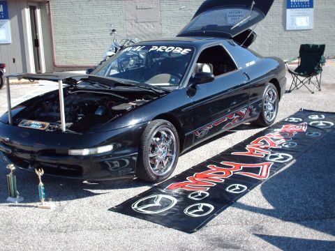 1995 Ford Probe - A black 1995 Ford Probe is displayed with its hood and trunk open at a car show.