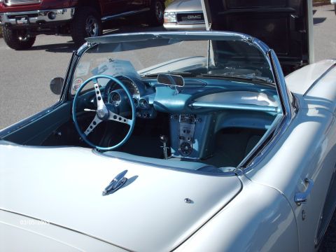 1995 Ford Probe - The interior of a classic white convertible is shown, with a blue dashboard and steering wheel, at an outdoor car show.