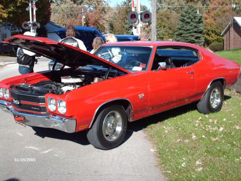 1995 Ford Probe - A red 1970 Chevrolet Chevelle SS is displayed with its hood open at an outdoor car show.