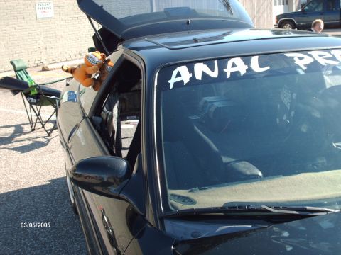 1995 Ford Probe - A black coupe is parked with its trunk open, a stuffed tiger visible in the driver's side window, and a decal on the windshield.