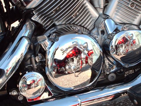 1995 Ford Probe - Reflection of a red motorcycle with flame graphics is visible in the chrome engine cover.