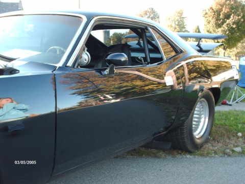 1995 Ford Probe - Side view of a modified 1970s muscle car with a roll cage and spoiler.