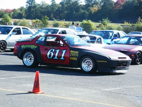 2001 Mercury Grand Marquis - A Porsche 944 race car with sponsor decals and the number 611 is parked at a track event.