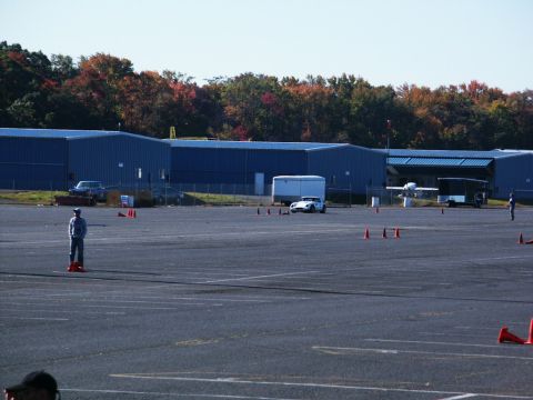 2001 Mercury Grand Marquis - A white sports car is positioned on a paved lot, with orange cones marking a course.
