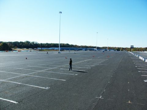 2001 Mercury Grand Marquis - A large, empty parking lot is shown on a clear day with a single person standing in the middle.