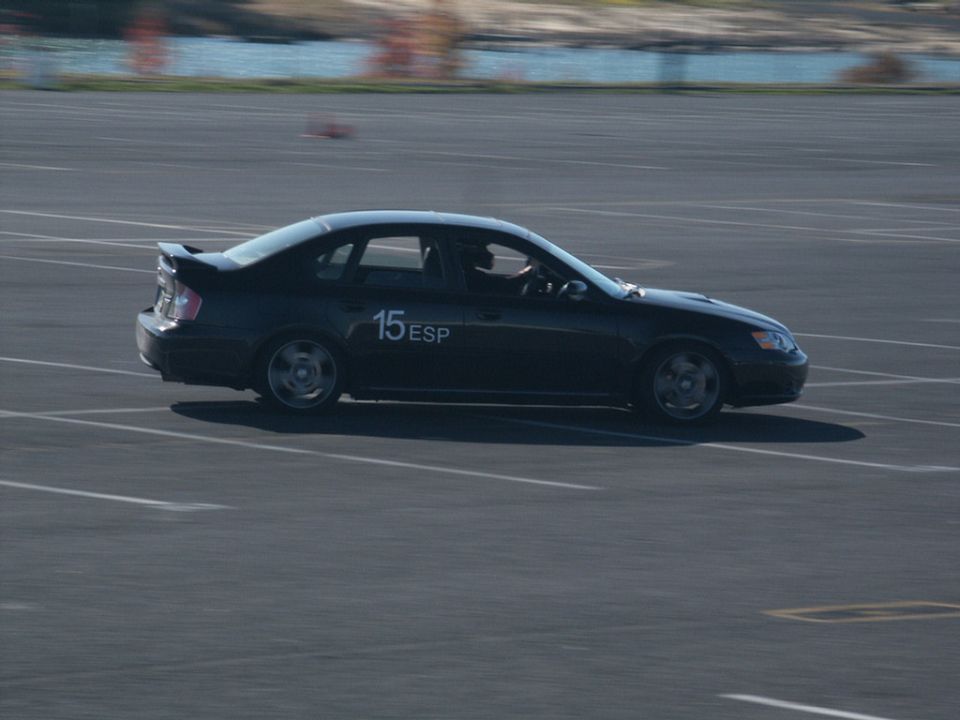 Black sedan with number 15 ESP on the door driving on a paved track