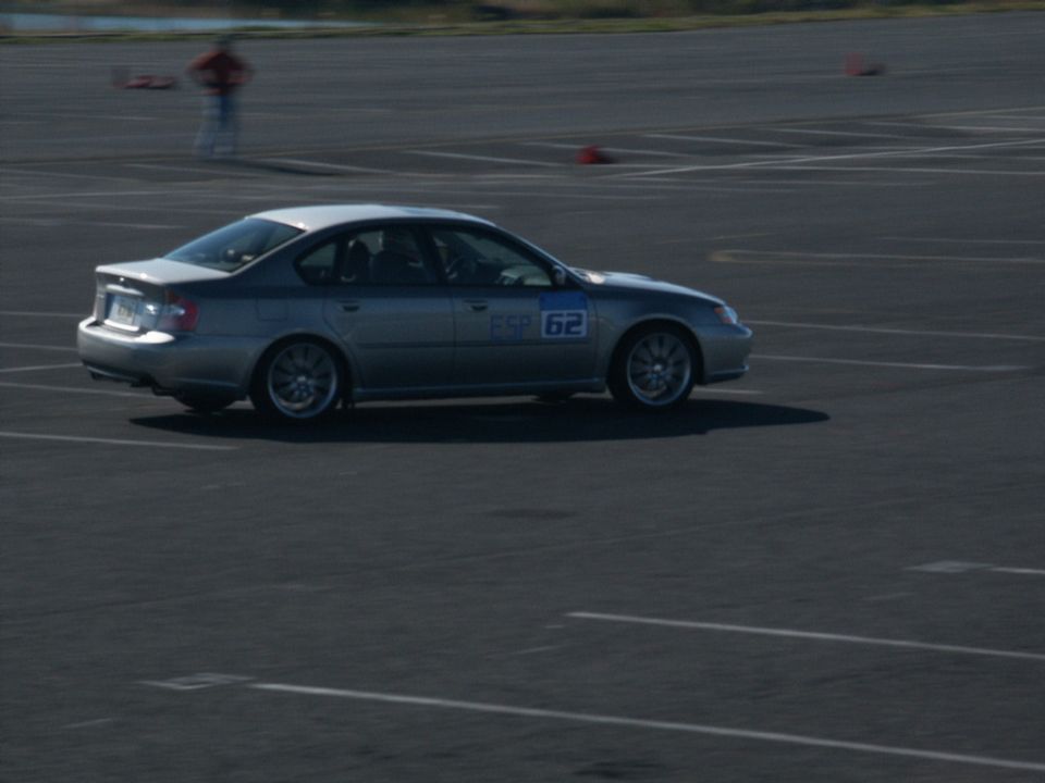 Silver sedan with number 62 on door driving on a track