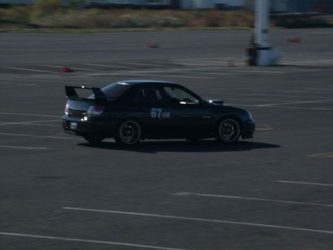 2001 Mercury Grand Marquis - A black Subaru WRX STI with racing numbers and a prominent rear spoiler is seen on a track during an event.