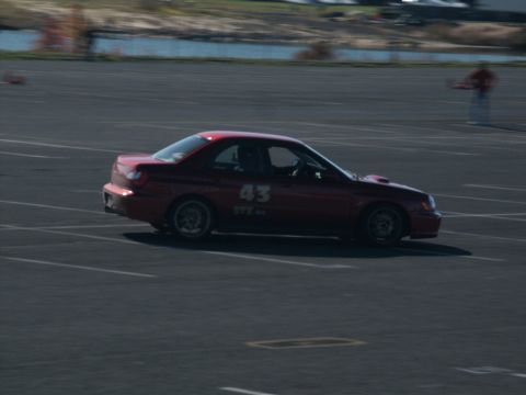 2001 Mercury Grand Marquis - A red sedan with racing numbers is seen on a track during a sunny day.