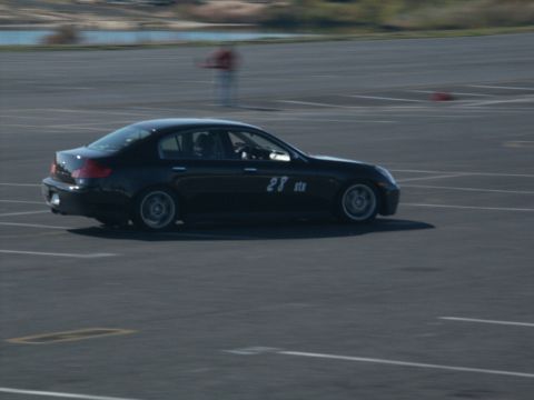 2001 Mercury Grand Marquis - A black sedan with racing number 28 is captured in motion on a race track.