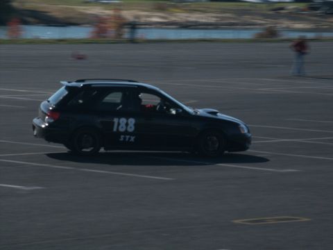 2001 Mercury Grand Marquis - A black Subaru Impreza WRX wagon with racing numbers is seen on a track.
