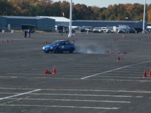 2001 Mercury Grand Marquis - A blue sedan navigates a course marked by orange cones on a sunny day.