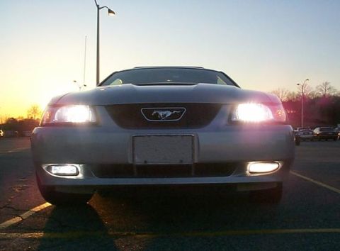 2000 Ford Mustang - Front view of a 2000 Ford Mustang, showing its headlights and fog lights illuminated.