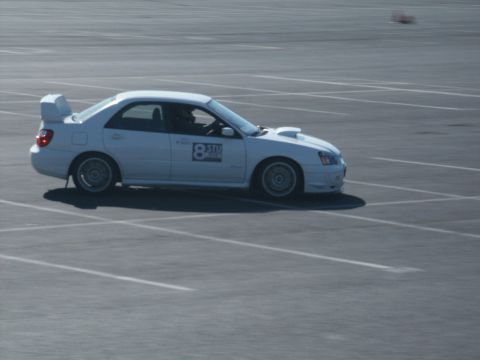 2001 Mercury Grand Marquis - A white Subaru Impreza WRX with racing decals is seen on a paved surface, possibly during an event.