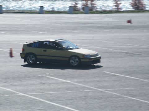 2001 Mercury Grand Marquis - A yellow Honda CRX navigates a course marked by cones on a sunny day.