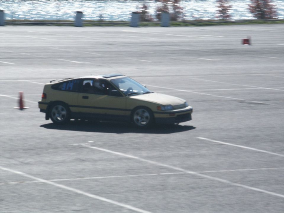 Yellow Honda CRX on a track with orange cones. Number 314 is on the window