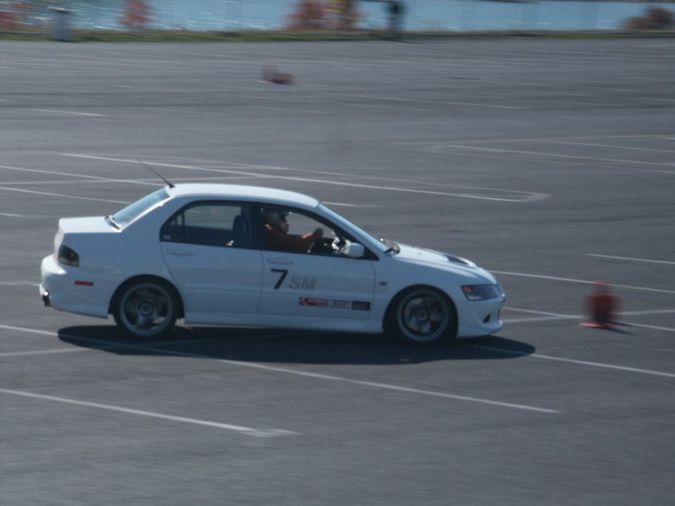 White sedan with racing decals and number 7 SM on the door, seen from the side