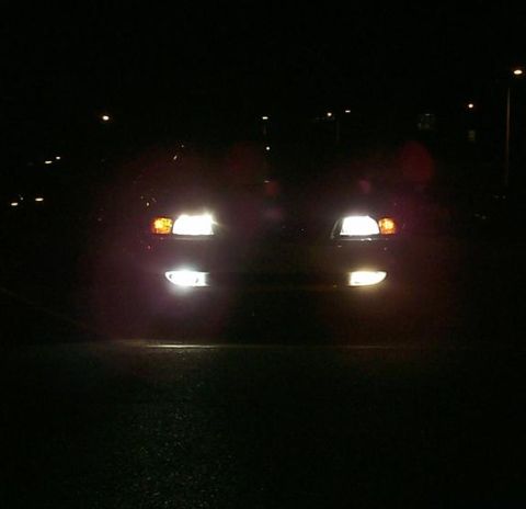 2000 Ford Mustang - The front of a car is visible at night with its headlights and fog lights on.