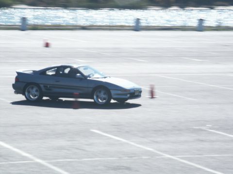 2001 Mercury Grand Marquis - A gray Toyota MR2 navigates a course marked by orange cones on a sunny day.