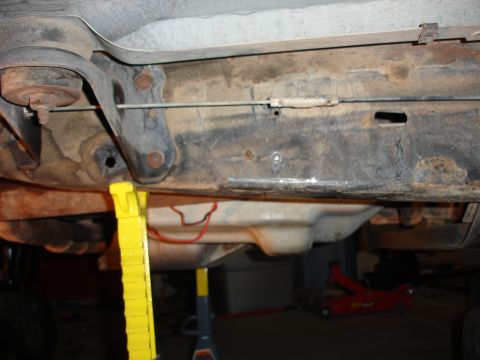 1996 Ford Bronco - Close-up view of a vehicle's undercarriage, showing frame components and support equipment.