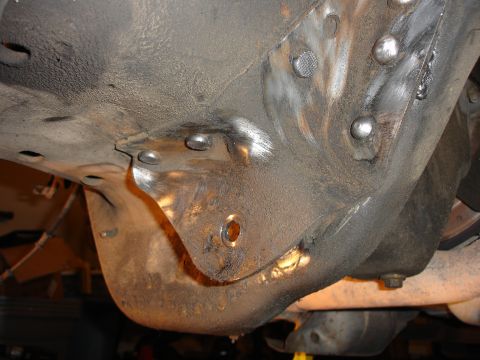 1996 Ford Bronco - Welding work on the underside of a vehicle frame, possibly for suspension modifications.