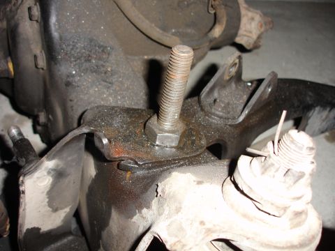 1996 Ford Bronco - Detail of a vehicle's suspension system, focusing on a bolt and mounting bracket.